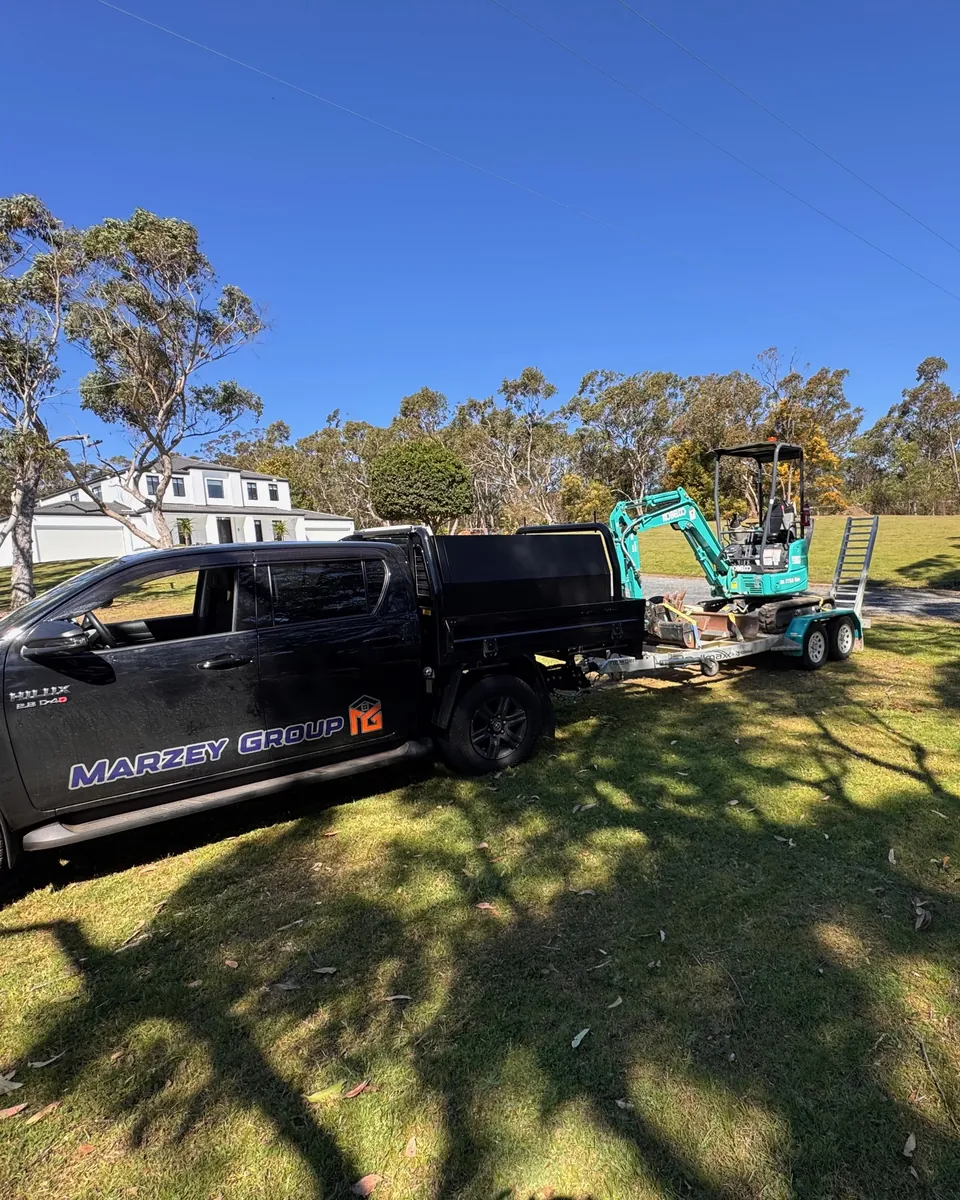 Marzey Group utility vehicle towing a compact excavator at a residential worksite